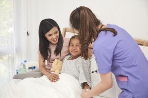 Female doctor and Young asian little patient with and mother smiling while doctor come to visit